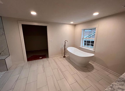Modern bathroom featuring a freestanding bathtub, neutral colors, and natural light.
